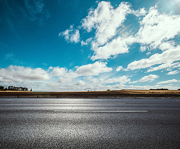 asphalt road under cloudy sky thumbnail
