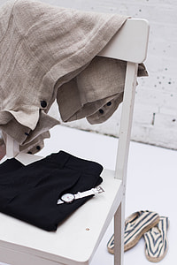 white analog watch on black pants pocket on white table thumbnail