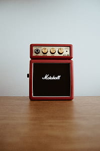 red Marschall guitar amplifier on brown wooden surface thumbnail