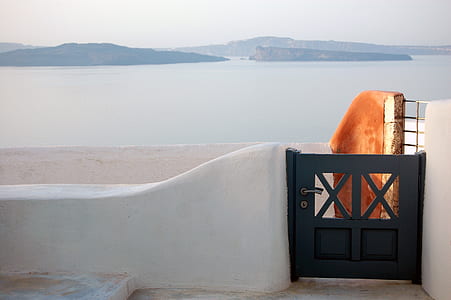 black wooden gate facing body of water at daytime thumbnail