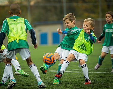 boys playing soccer during daytime thumbnail