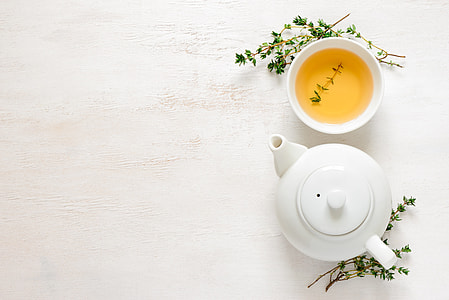 white ceramic teapot beside teacup with tea thumbnail