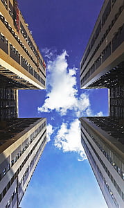 worm's eye view of two concrete buildings under blue sky thumbnail