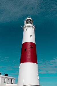 red and white lighthouse under clear blue sky thumbnail
