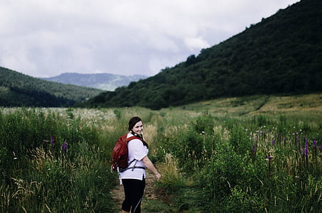 woman wearing backpack at grass field thumbnail