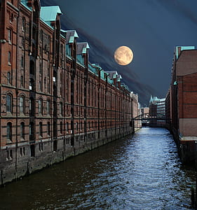 photo of body of water between brown concrete building thumbnail