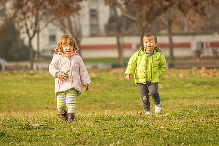 girl and boy standing on green grass thumbnail