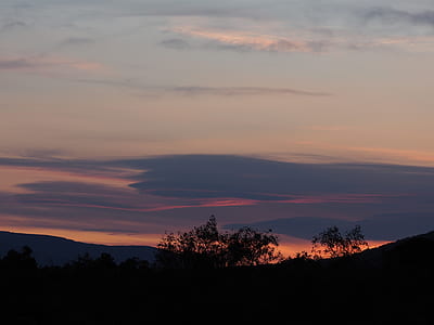 silhouette photograph of hill and trees during golden hour thumbnail