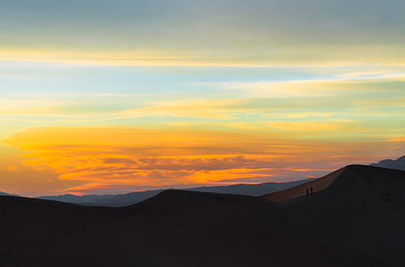 silhouette of two person standing on mountain thumbnail
