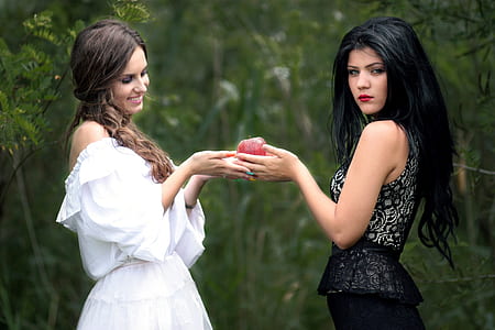 woman receiving apple from another woman thumbnail