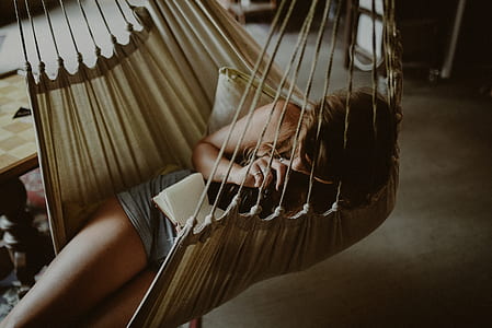 person lay on white swing thumbnail