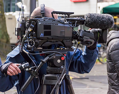 person standing in front of professional video camera thumbnail