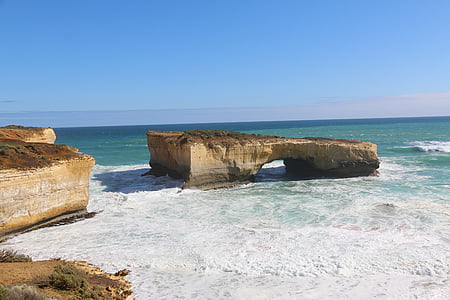 rock formations beyond body of water thumbnail