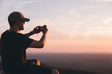 man sitting holding smartphone thumbnail