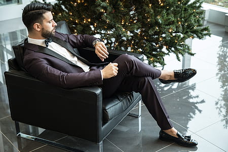 man in purple suit sitting on sofa chair thumbnail