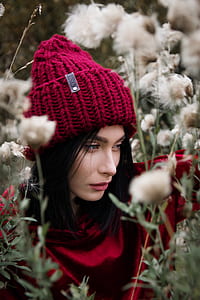 closeup photo of woman wearing knit cap surrounded by dandelion flowers thumbnail