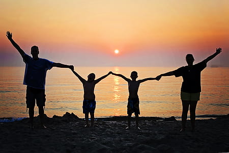 family silhouette on seashore during sunset thumbnail