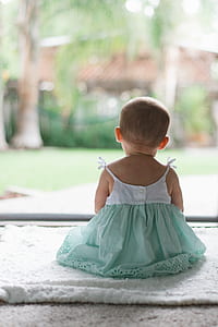 girl sitting on floor facing garden thumbnail