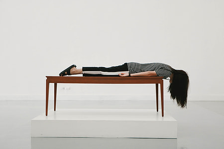 woman planking on top brown table near wall thumbnail