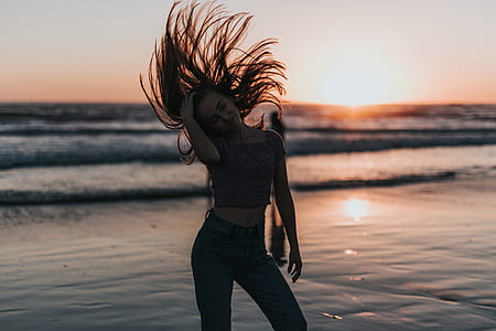 woman standing on sandbank while flipping her hair thumbnail