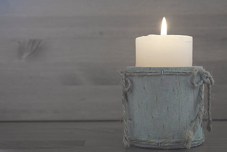 white pillar candle on gray wooden case thumbnail
