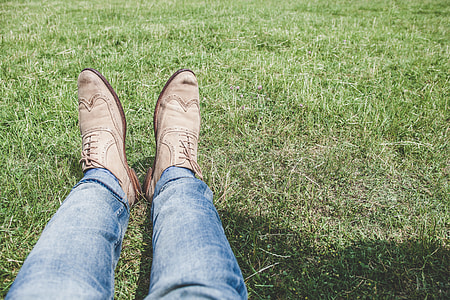 person wearing blue-washed jeans and pair of gray leather wing-tip dress shoes thumbnail
