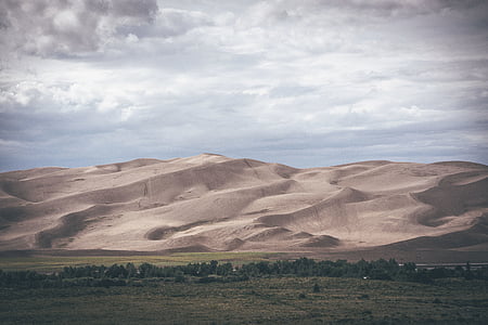 brown desert in front of green grass field thumbnail