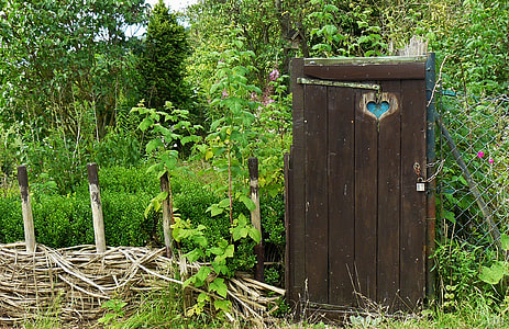 locked toilet shed beside fence near trees during day thumbnail
