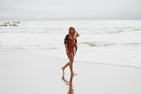 woman wearing red shorts walking on shoreline thumbnail