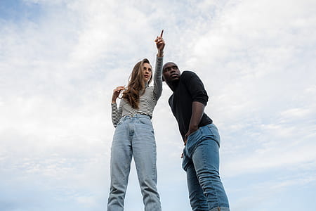 woman pointing while standing beside man thumbnail
