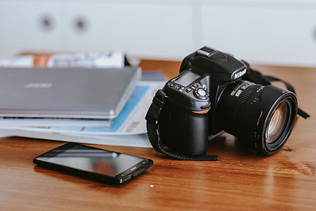 Laptop, a smartphone, magazines and cups of coffee on a table thumbnail