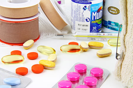assorted-color pills near thermometer thumbnail