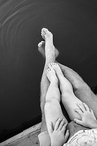 man and child sitting near body of water thumbnail