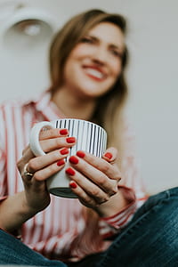 woman holding white and black ceramic cup selective photography thumbnail
