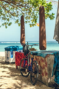 blue and gray bicycle parked near table background of ocean thumbnail