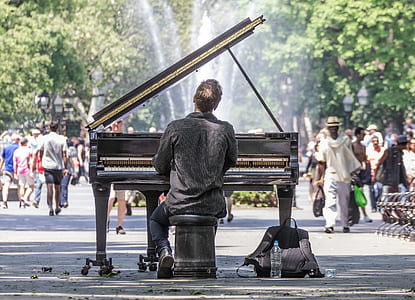 back view of man playing grand piano in front of people thumbnail