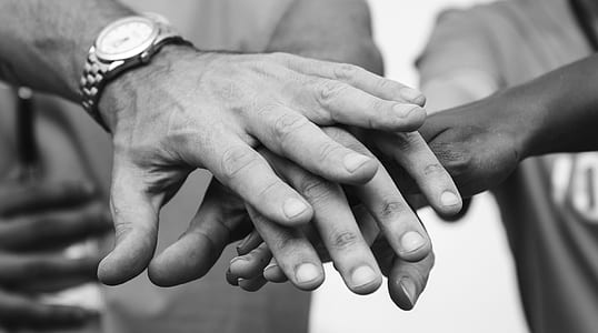 people putting together their hands grayscale photography thumbnail