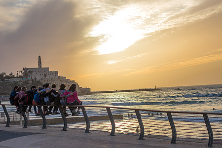 people sitting on meta barrier front of sea during golden hour thumbnail