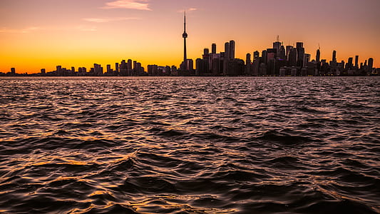 cityscape beside body of water during golden hour thumbnail