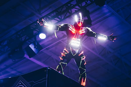 person wearing overall with light standing on stage thumbnail