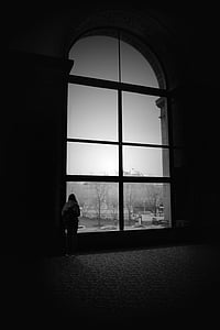 grayscale photography of person standing on window thumbnail