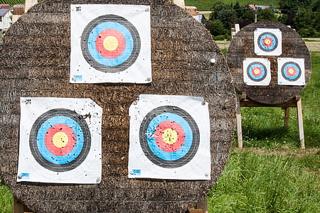 three white target sheets on round brown board thumbnail
