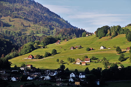 white houses near green mountain at daytime thumbnail