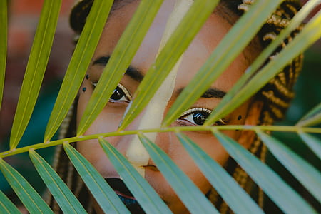 green coconut leaf in front of woman face thumbnail