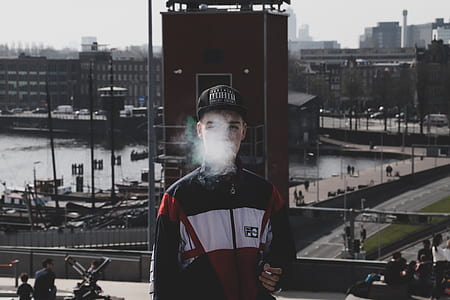 person smoking on front of red tower thumbnail