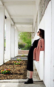 woman leaning on white painted wall thumbnail