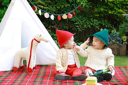 two babies sitting on red and green plaid textile thumbnail