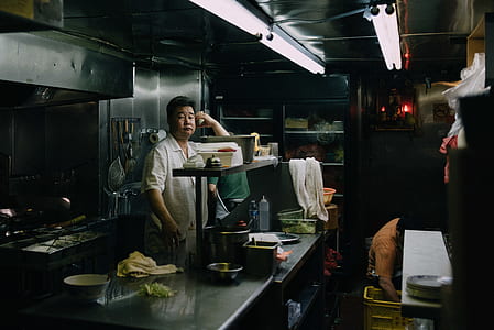 man standing behind kitchen cabinet thumbnail
