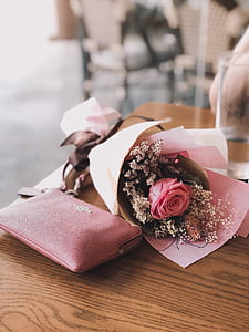 photo of bouquet of flowers beside pink Coach leather wristlet thumbnail