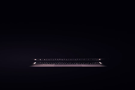 Laptop computer sitting in a dark room thumbnail